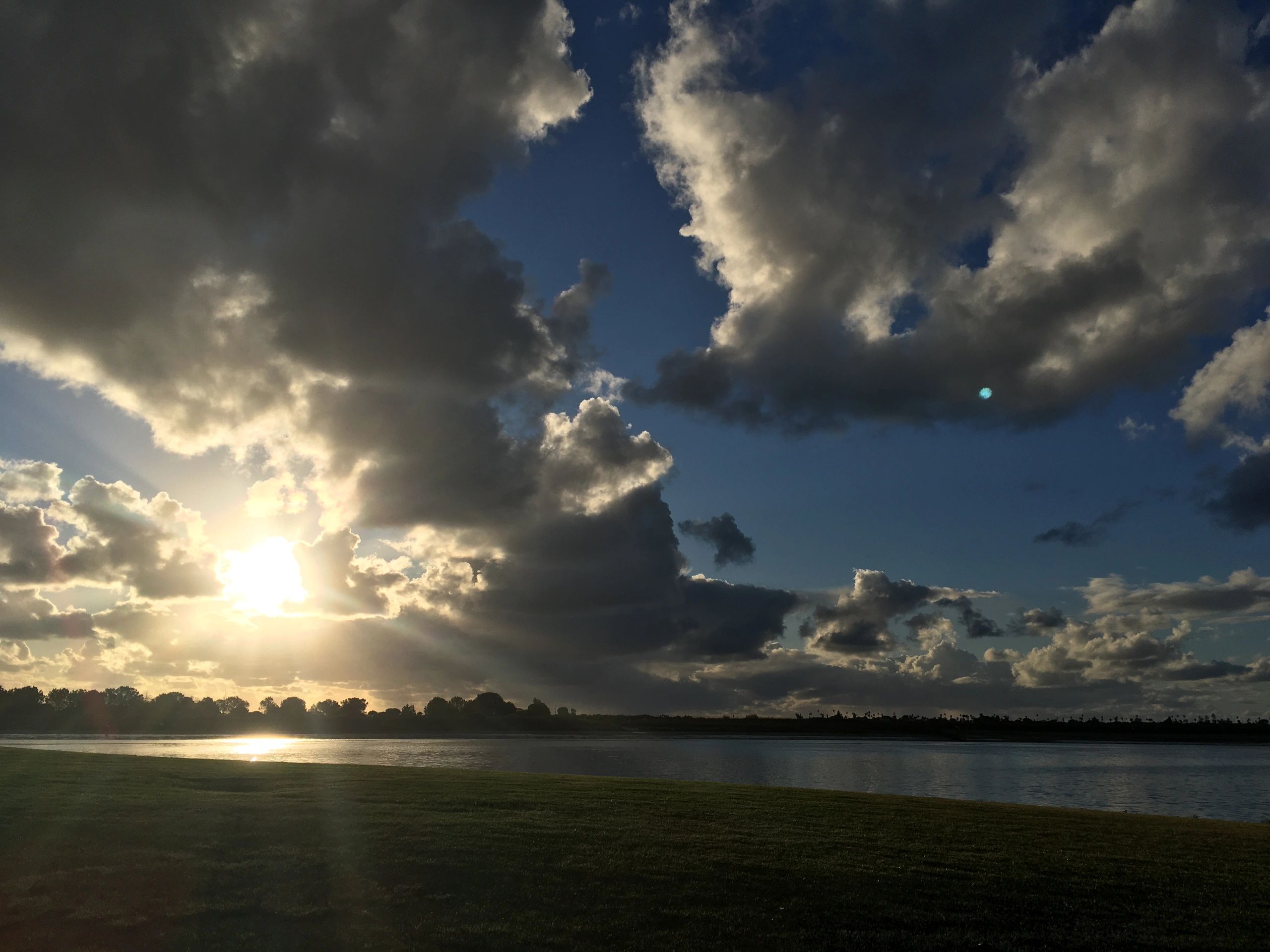 Serene waterfront landscape with dramatic clouds